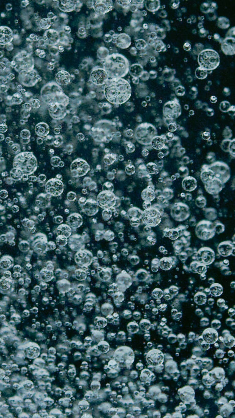 Dynamic vertical abstract image of air bubbles in water, creating a modern and artistic effect.